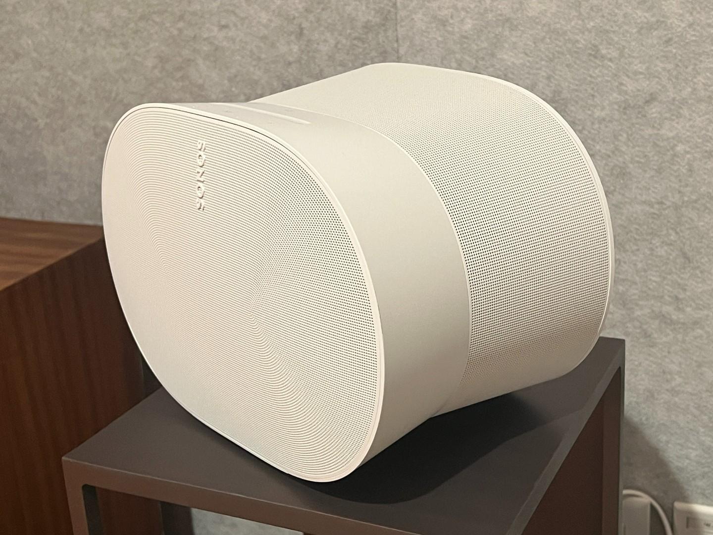 A white Era 300 speaker sits on a small table facing left in a demo room.