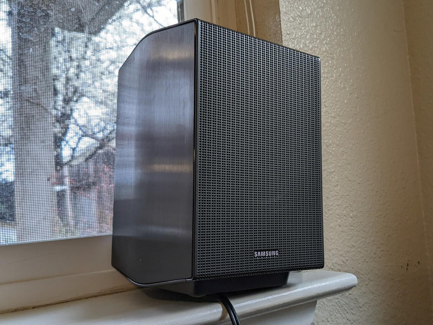 The Samsung HW-Q990C surround sound speaker shines in the light on the ledge of a window