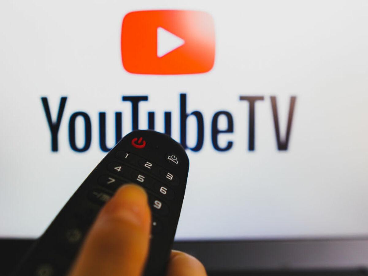 Youtube TV sign and a person's hand holding a remote
