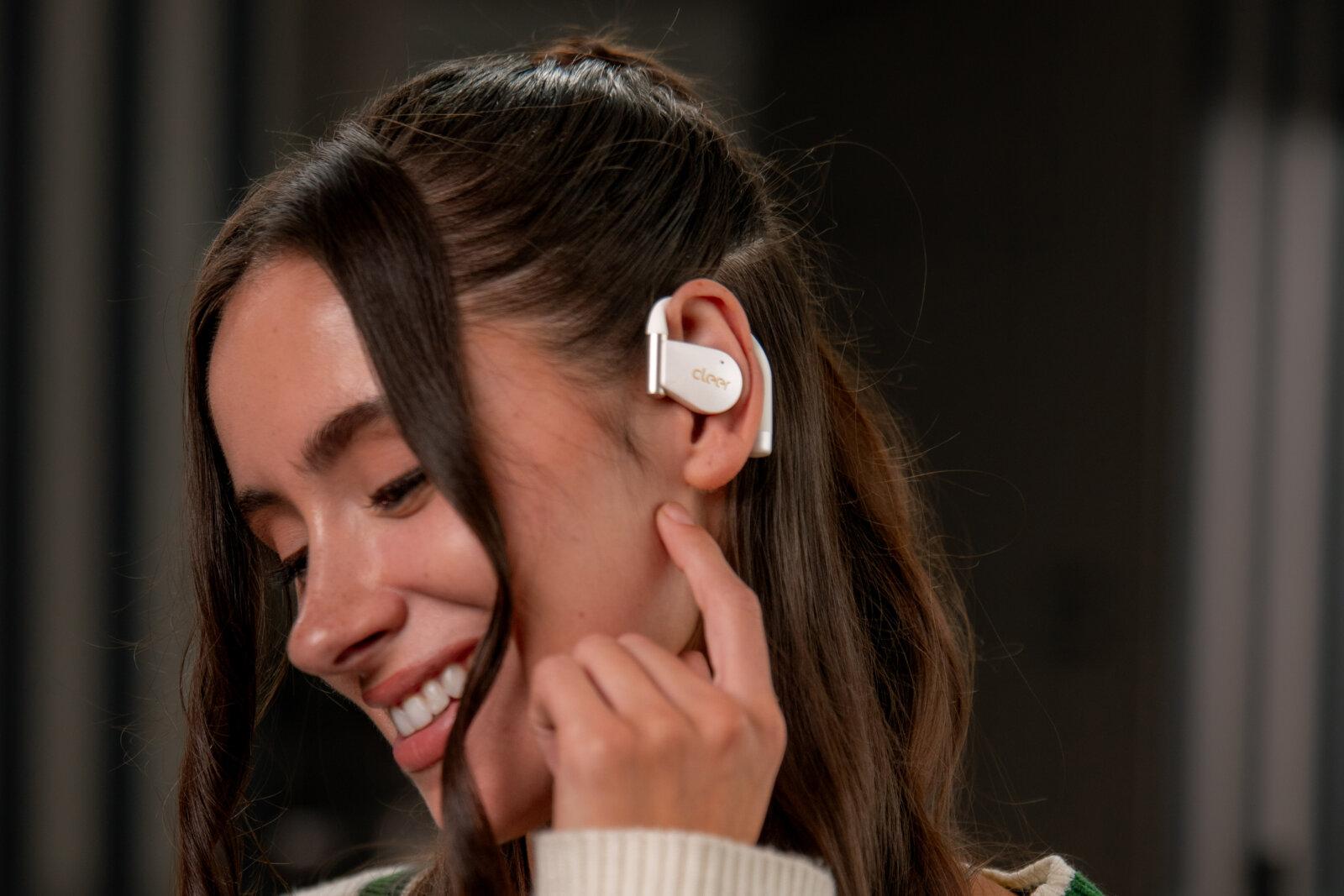 Woman wearing Cleer Arc 4 earbuds.